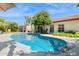Beautiful kidney-shaped pool with a modern pool cleaner, surrounded by a concrete deck and lush greenery at 2236 E Sierra St, Phoenix, AZ 85028