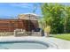 Relaxing poolside lounge area featuring comfortable seating and an umbrella for shade, set against a decorative fence at 2236 E Sierra St, Phoenix, AZ 85028