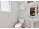 Powder room featuring pedestal sink, toilet, and round mirror at 2401 E Rio Salado Pkwy # 1047, Tempe, AZ 85288