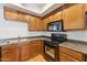 Close up of the kitchen with wood cabinets and drawers, as well as black appliances at 2401 E Rio Salado Pkwy # 1047, Tempe, AZ 85288