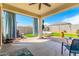 Cozy covered back patio featuring a ceiling fan and blue accent curtains at 30128 W Weldon Ave, Buckeye, AZ 85396