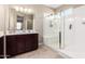 Well-lit bathroom featuring modern vanity, a large mirror, and a glass-enclosed shower at 30128 W Weldon Ave, Buckeye, AZ 85396