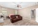 Comfortable living room featuring plush carpeting, a ceiling fan, and a reclining sofa at 30128 W Weldon Ave, Buckeye, AZ 85396