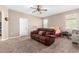 Comfortable living room featuring plush carpeting, a ceiling fan, and a reclining sofa at 30128 W Weldon Ave, Buckeye, AZ 85396