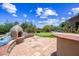 An outdoor fireplace and kitchen area with artificial grass and desert landscaping at 33317 N 71St St, Scottsdale, AZ 85266