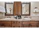 Elegant bathroom featuring double vanity with granite counters and decorative mirrors at 33317 N 71St St, Scottsdale, AZ 85266