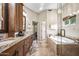 Beautiful bathroom with double vanity, granite countertops, and a soaking tub with a glass enclosure at 33317 N 71St St, Scottsdale, AZ 85266