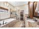 Elegant bathroom featuring a soaking tub, glass shower, and granite vanity with storage and a walk-in closet at 33317 N 71St St, Scottsdale, AZ 85266