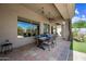 A covered patio with outdoor dining table next to well manicured landscaping at 33317 N 71St St, Scottsdale, AZ 85266