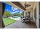 A covered patio with outdoor seating next to a swimming pool, artificial grass, and desert landscaping at 33317 N 71St St, Scottsdale, AZ 85266