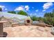 A built-in outdoor fireplace with cushioned benches located on a tiled patio at 33317 N 71St St, Scottsdale, AZ 85266