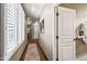 Well-lit hallway with wood floors leading to a bathroom with natural light and storage at 33317 N 71St St, Scottsdale, AZ 85266