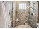 Detailed view of the walk-in shower featuring decorative tile, seat, and updated fixtures at 33317 N 71St St, Scottsdale, AZ 85266