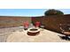 Cozy backyard patio featuring a charming fire pit, comfortable seating, and a well-maintained paver area perfect for entertaining at 42382 W Hillman Dr, Maricopa, AZ 85138