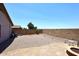 Spacious backyard with gravel, a charming brick patio, and a fire pit, offering a blank canvas for creating your dream outdoor oasis at 42382 W Hillman Dr, Maricopa, AZ 85138