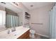 Neutral bathroom with a tile floor, wood vanity, and accessible grab bars at 42382 W Hillman Dr, Maricopa, AZ 85138