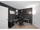 Bedroom featuring a black brick wall, neutral carpet, and a modern desk setup at 42382 W Hillman Dr, Maricopa, AZ 85138