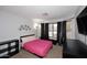 Cozy bedroom with a pink bedspread, large windows, and a TV at 42382 W Hillman Dr, Maricopa, AZ 85138