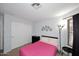 Bedroom featuring a pink bed, closet, and a flower wall decoration at 42382 W Hillman Dr, Maricopa, AZ 85138