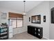 Cozy dining area with ample natural light and neutral tones, featuring a sleek storage unit and decorative mirror at 42382 W Hillman Dr, Maricopa, AZ 85138