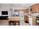 Spacious kitchen with tile floors, wooden cabinets, stainless steel appliances, and a breakfast bar at 42382 W Hillman Dr, Maricopa, AZ 85138