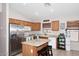 Bright kitchen with tile floors, wooden cabinets, stainless steel appliances, and ample counter space at 42382 W Hillman Dr, Maricopa, AZ 85138