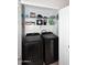 Efficient laundry closet with side-by-side washer and dryer, and storage shelving, creating a practical laundry area at 42382 W Hillman Dr, Maricopa, AZ 85138