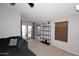Bright living room with sliding glass doors, plush sofa, and stylish shelving unit for a modern, airy feel at 42382 W Hillman Dr, Maricopa, AZ 85138