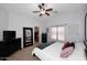 Spacious main bedroom with a ceiling fan, large window, and ensuite bathroom access, offering comfort and convenience at 42382 W Hillman Dr, Maricopa, AZ 85138