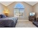 Bedroom features a large arched window, neutral carpet, and a television at 4601 N 102Nd Ave # 1055, Phoenix, AZ 85037