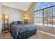 Bedroom features a large arched window, neutral carpet, and comfortable furnishings at 4601 N 102Nd Ave # 1055, Phoenix, AZ 85037
