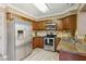 Well-lit kitchen features stainless steel appliances, wooden cabinets, and stone countertops at 4601 N 102Nd Ave # 1055, Phoenix, AZ 85037