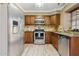 Well-lit kitchen boasts stainless steel appliances, wooden cabinets, and stone countertops at 4601 N 102Nd Ave # 1055, Phoenix, AZ 85037