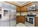 Open kitchen featuring stainless steel appliances, wooden cabinets, and modern countertops at 4601 N 102Nd Ave # 1055, Phoenix, AZ 85037