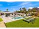 Backyard boasts a sparkling pool, covered patio, lush lawn, and mountain views for outdoor enjoyment at 4633 N 49Th Pl, Phoenix, AZ 85018