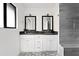 Modern bathroom featuring a double vanity with white cabinetry, black countertops, and framed mirrors at 4633 N 49Th Pl, Phoenix, AZ 85018