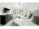 Well-lit bedroom with twin beds, modern decor, and a view of the outdoors through a large window at 4633 N 49Th Pl, Phoenix, AZ 85018
