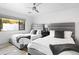 Inviting bedroom with two twin beds, soft gray headboards, and a modern ceiling fan for added comfort at 4633 N 49Th Pl, Phoenix, AZ 85018