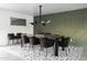 Modern dining area with a large table, elegant chairs, and a textured green accent wall at 4633 N 49Th Pl, Phoenix, AZ 85018