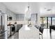 Bright kitchen with gray cabinets, quartz countertop island, and view of the backyard through sliding doors at 4633 N 49Th Pl, Phoenix, AZ 85018
