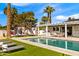 Resort-style backyard features a sparkling pool, lounge chairs, daybeds, and outdoor kitchen at 4633 N 49Th Pl, Phoenix, AZ 85018
