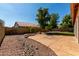 Tranquil backyard featuring decorative rocks, a stone bench, mature trees, and a paved patio at 5517 W Aster Dr, Glendale, AZ 85304