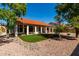 Landscaped backyard featuring artificial turf, decorative rocks, a tiled roof and a covered patio at 5517 W Aster Dr, Glendale, AZ 85304