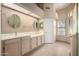 Bright bathroom featuring a double vanity, round mirrors, and a neutral color palette for a clean, modern aesthetic at 5517 W Aster Dr, Glendale, AZ 85304