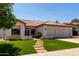 Charming single-story home featuring desert landscaping, a tile roof, and a two-car garage at 5517 W Aster Dr, Glendale, AZ 85304