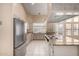 Kitchen view showcasing stainless steel fridge, cooktop island, and neutral colored cabinets at 5517 W Aster Dr, Glendale, AZ 85304