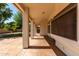 Covered patio with stamped concrete flooring, offering a comfortable outdoor living space and backyard access at 5517 W Aster Dr, Glendale, AZ 85304