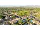 Expansive aerial view of a neighborhood with mature trees, a green park and views of the mountains at 6435 E Monte Cristo Ave, Scottsdale, AZ 85254