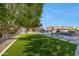 Expansive backyard features lush green lawn, mature trees, and a sparkling pool, ideal for outdoor living and entertainment at 6435 E Monte Cristo Ave, Scottsdale, AZ 85254