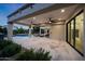 Expansive covered patio with travertine tile, ceiling fans, and a seamless transition to the outdoor living space at 6435 E Monte Cristo Ave, Scottsdale, AZ 85254